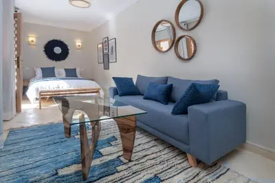 a living room with a blue couch and a bed at Riad Le Saadien ,Adult only in Marrakech