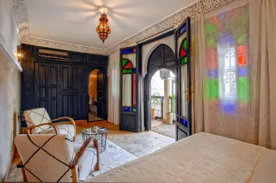 a room with stained glass windows and a table at Riad Basim in Marrakech