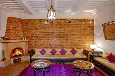 a living room with a couch and a brick wall at Riad Basim in Marrakech
