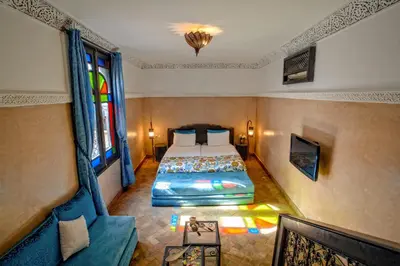 a bedroom with a bed in a room with a window at Riad Basim in Marrakech