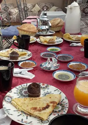 a table topped with plates of food and orange juice at Riad Nouhal in Marrakech
