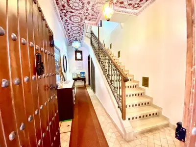 a hallway with wooden lockers and stairs in a house at Riad Nouhal in Marrakech