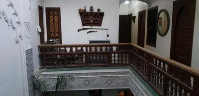 a staircase in a house with wooden railing at Riad Nouhal in Marrakech
