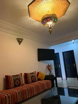 a living room with a couch and a chandelier at diamant Marrakech centre in Marrakech