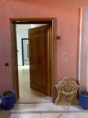 a wooden door in a room with two pots at diamant Marrakech centre in Marrakech