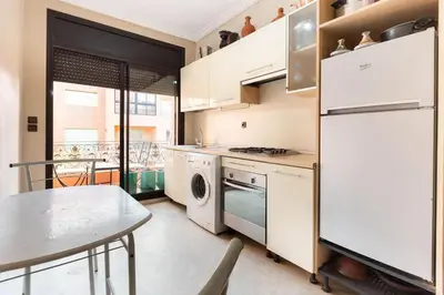 a kitchen with a white refrigerator and a table at diamant Marrakech centre in Marrakech