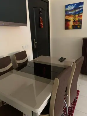 a dining room table with chairs and a black door at Appartement zen in Marrakech