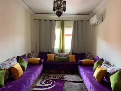 a living room with a purple couch with colorful pillows at Appartement zen in Marrakech