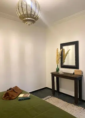 a room with a table and a chandelier and a mirror at Riad Ksar Saad & Spa in Marrakech