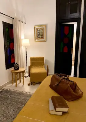 a room with a bed with a book and a chair at Riad Ksar Saad & Spa in Marrakech