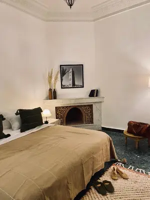 a bedroom with a bed and a fireplace at Riad Ksar Saad & Spa in Marrakech