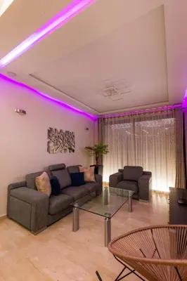 a living room with purple lights on the ceiling at Le soleil de Marrakech in Marrakech