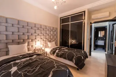 a bedroom with two beds and a wall at Le soleil de Marrakech in Marrakech