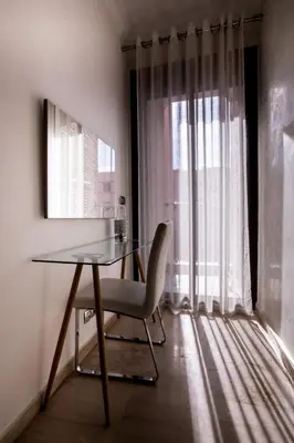 a table and a chair in a room with a window at Le soleil de Marrakech in Marrakech