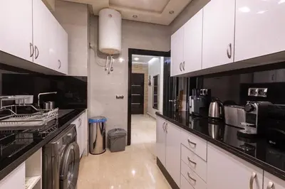 a kitchen with white cabinets and a washer and dryer at Le soleil de Marrakech in Marrakech
