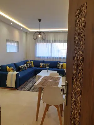 a living room with a blue couch and a table at Apparemment yasmina in Marrakech