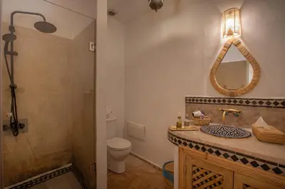 a bathroom with a sink and a toilet and a mirror at Riad Tassili Marrakech in Marrakech