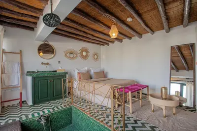 a bedroom with a bed and a desk and a table at Riad Tassili Marrakech in Marrakech