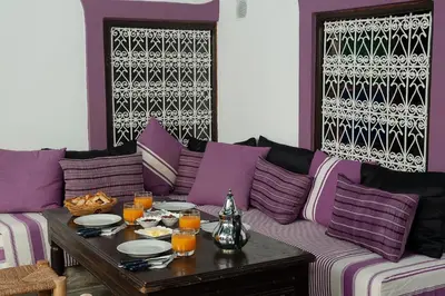 a living room with a purple couch with a table at Dar Le Fennec in Marrakech