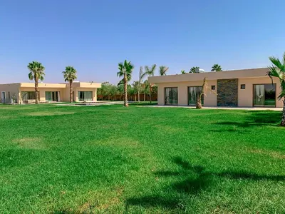 a building with a large lawn in front of it at Villa des sœurs bradaa in Marrakech