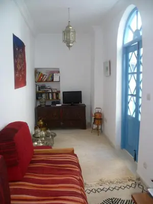 a living room with a red couch and a blue door at Dar Daoud in Marrakech