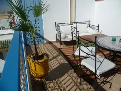 a balcony with a potted plant and a table and chairs at Dar Daoud in Marrakech