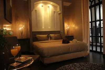 a bedroom with a bed with a mirror on the wall at Riad Carllian in Marrakech