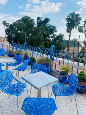 a group of blue chairs and tables with plants at Hostel Essassi 23 in Marrakech