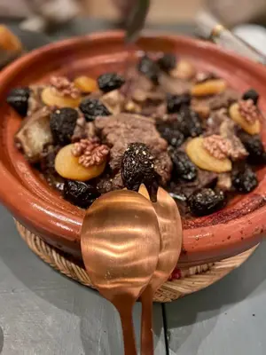 a bowl of food on a table with a spoon at RIAD MAGIE Boutique Hotel in Marrakech