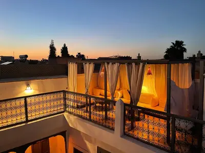 a balcony with curtains and furniture on a building at RIAD MAGIE Boutique Hotel in Marrakech