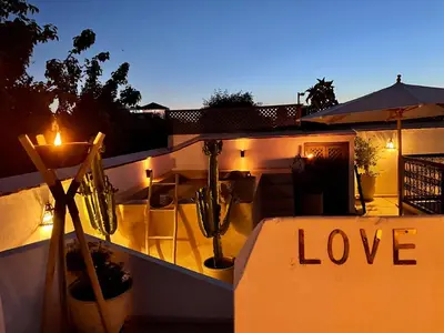 a sign that says love sitting on a balcony at night at RIAD MAGIE Boutique Hotel in Marrakech