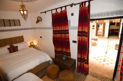 a bedroom with a bed and a door to a courtyard at Riad Vis Ta Vie in Marrakech