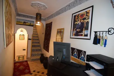 a living room with a tv and a staircase in a house at Riad Vis Ta Vie in Marrakech