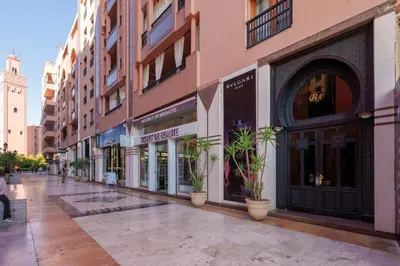an empty street with potted plants in front of buildings at Appartement Haut Standing Gueliz Plaza avec Vue in Marrakech