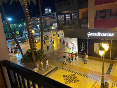 a group of people walking on a street at night at Appartement Haut Standing Gueliz Plaza avec Vue in Marrakech