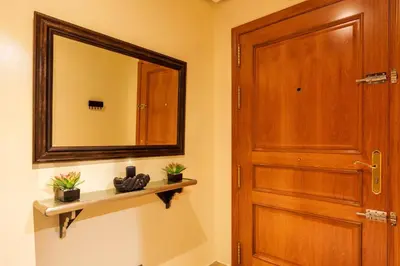 a bathroom with a mirror and a wooden door at Appartement Haut Standing Gueliz Plaza avec Vue in Marrakech