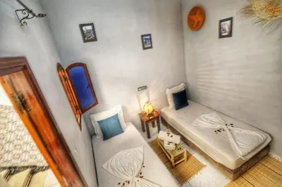 a small room with two beds and a table at Riad Amirkesh and Pool in Marrakech