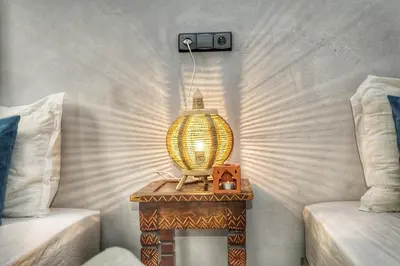a lamp on a table next to two beds at Riad Amirkesh and Pool in Marrakech
