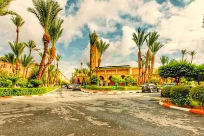 a street with palm trees in front of a building at Riad Amirkesh and Pool in Marrakech