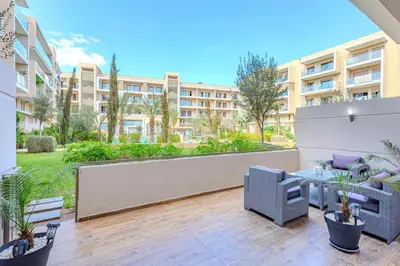 a patio with chairs and a table in a apartment at Royal Deluxe Gold - Marrakech, Luxe Pool View in Marrakech