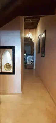 a hallway in a house with paintings on the walls at Hôtel La Citta Rossa in Marrakech