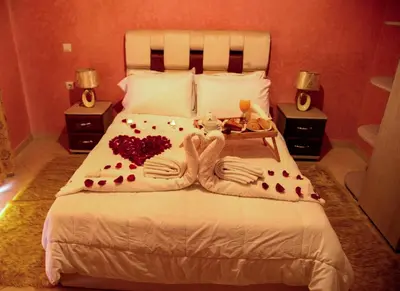 a bedroom with a bed with two people made out of hearts at Hôtel La Citta Rossa in Marrakech