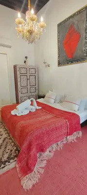 a bedroom with two beds and a chandelier at Riad Siena II in Marrakech