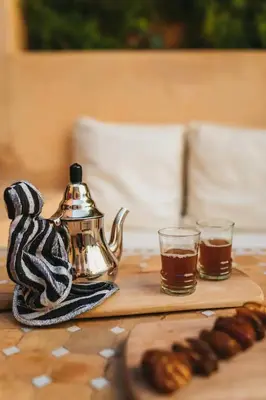 a tea kettle and two glasses of tea on a table at Riad Siena II in Marrakech