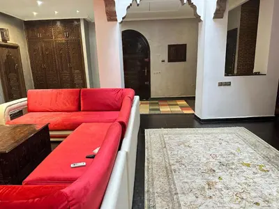 a living room with a red couch and a rug at Riad luna in Marrakech