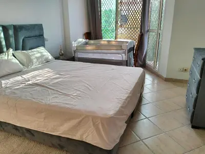 a bedroom with a bed and two chairs and a window at Perfect only family apartment & air cooling in Marrakech