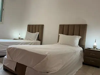 a bedroom with two beds with white sheets at Perfect only family apartment & air cooling in Marrakech