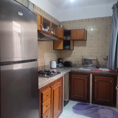 a kitchen with wooden cabinets and a stainless steel refrigerator at Perfect only family apartment & air cooling in Marrakech