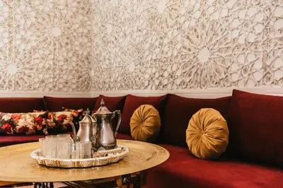 a couch with a table with a tea kettle on it at L'Emeraude de la Médina in Marrakech
