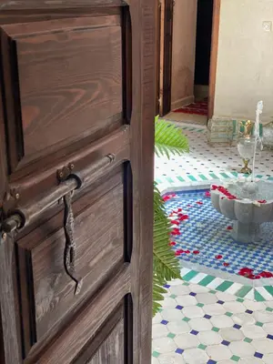 a wooden door in a room with a floor at L'Emeraude de la Médina in Marrakech